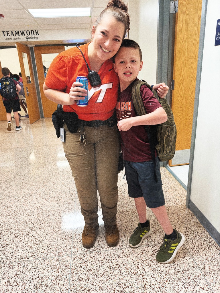 Smiling School Rewource Officer and elementary student showing off their Virginia Tech colors and shirts