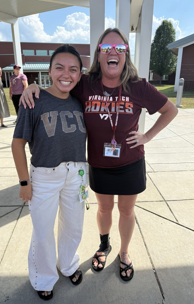 Two women smiling outside, one in a VCU shirt and the other in a Virginia Tech shirt and pink sunglasses.