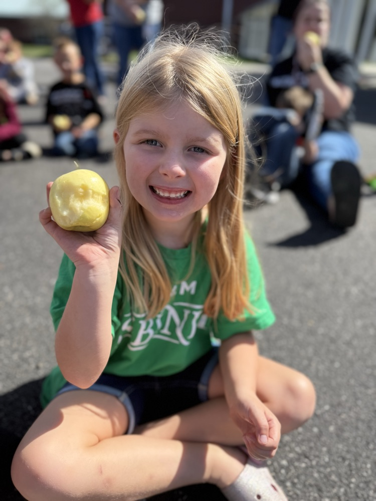 Young child holding an apple.
