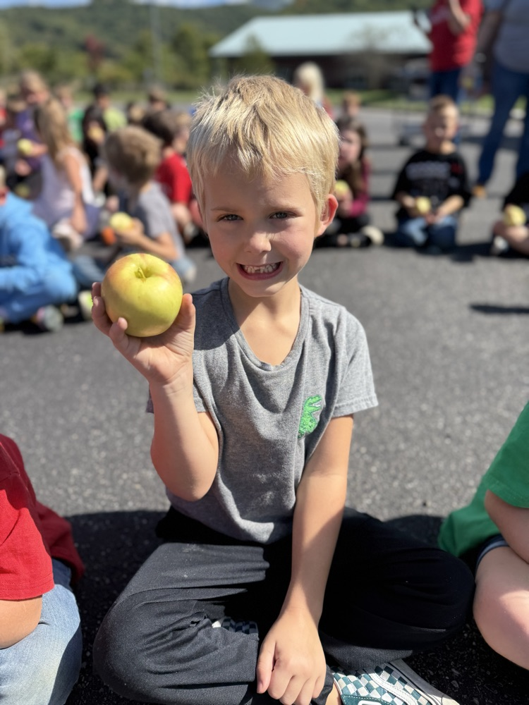 Young child holding an apple.