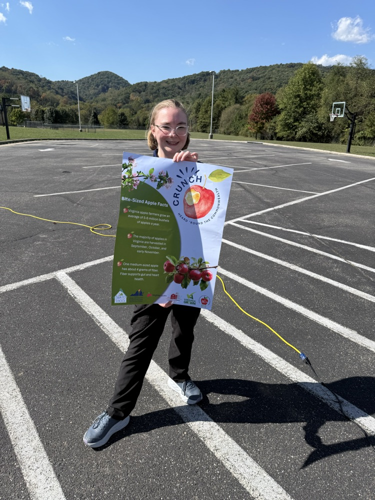 An adult holding an apple poster.