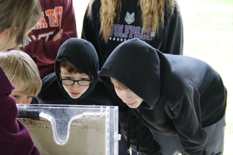 Two students staring intently at a demonstration at stormwater days