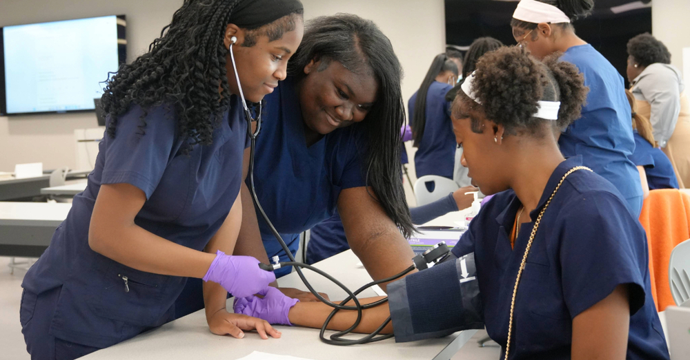 three students taking blood pressure