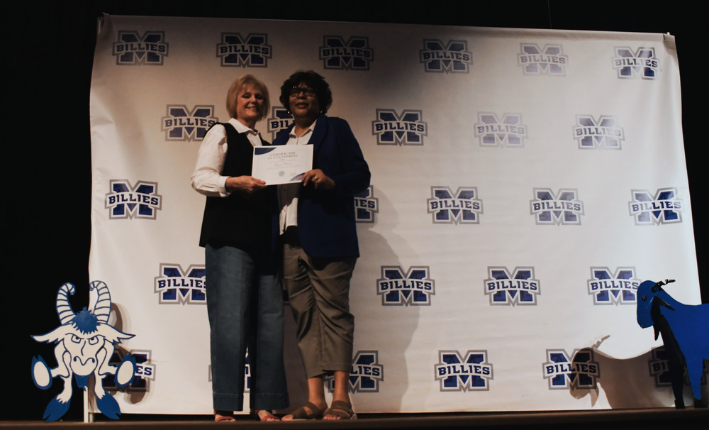 2 ladies standing holding award