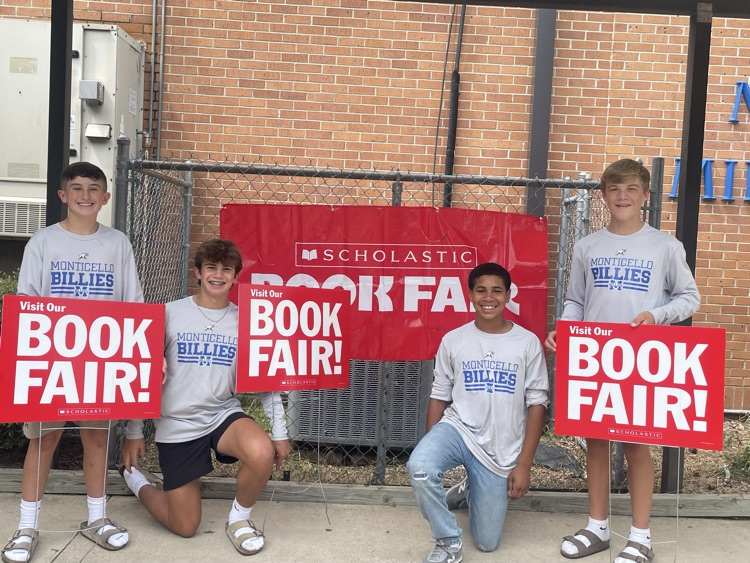 students holding book fair signs for MMS