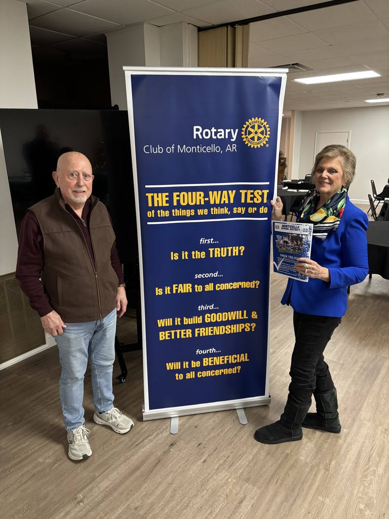 lady standing beside man with rotary sign
