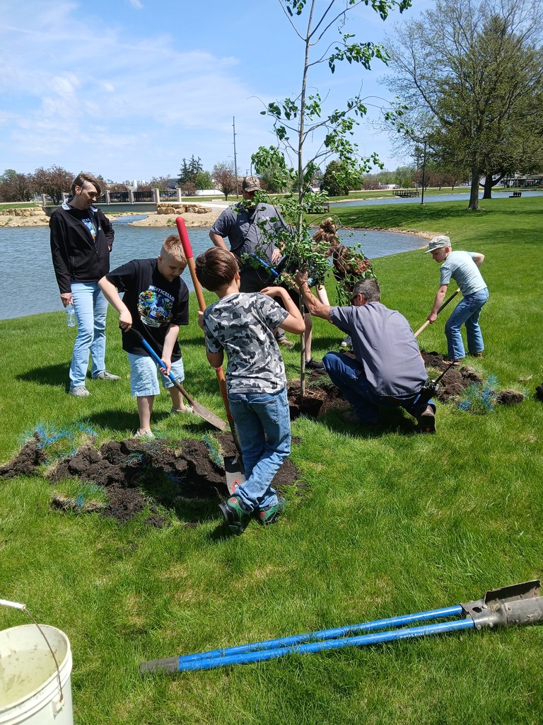 students and adults planting a tree