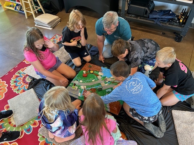 2nd-4th graders playing a board game at Nature of the Confluence in Beloit, WI