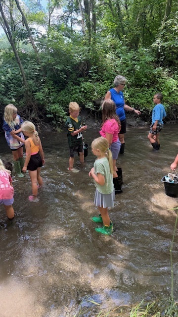 2nd-4th graders wading in the water at Nature of the Confluence in Beloit, WI