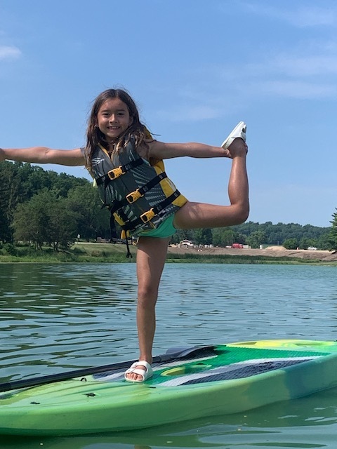 elementary student on paddle board