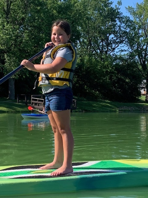 elementary student paddle boarding