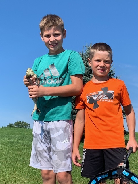 two elementary students holding a fish
