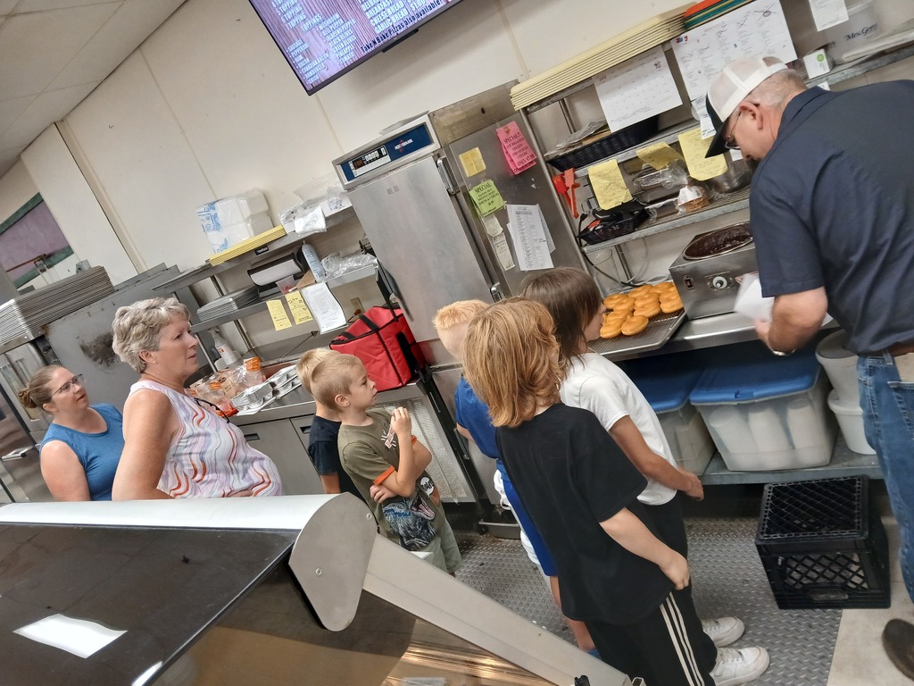 elementary students and teachers at grocery store making donuts