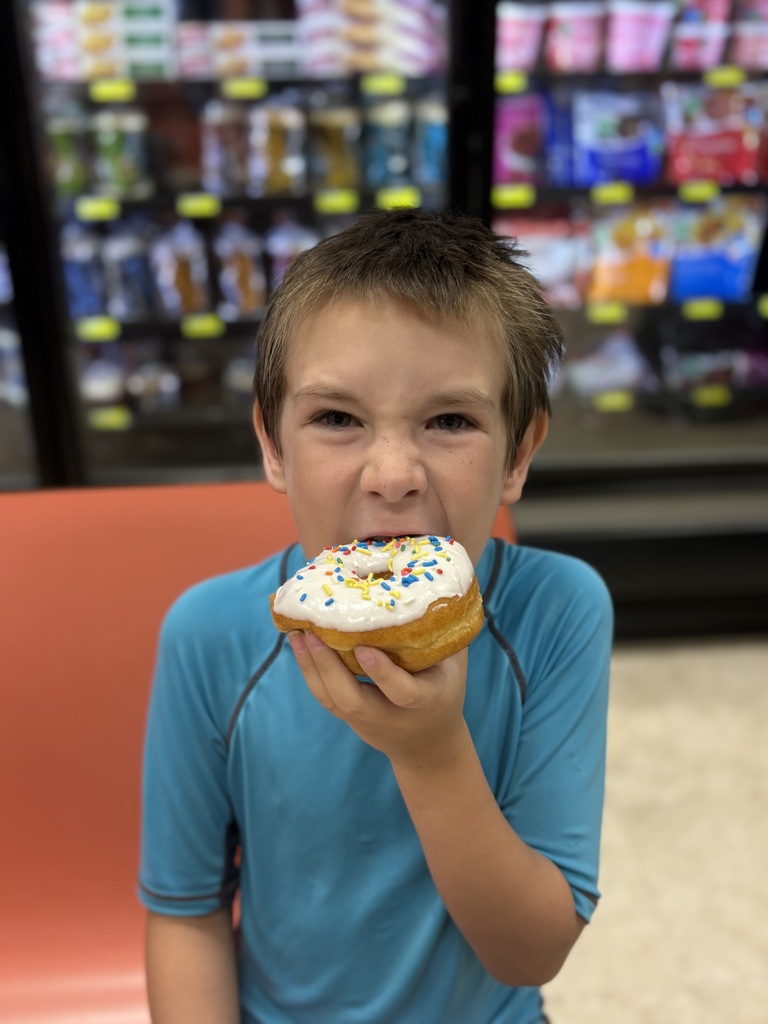 elementary student eating donut at grocery store