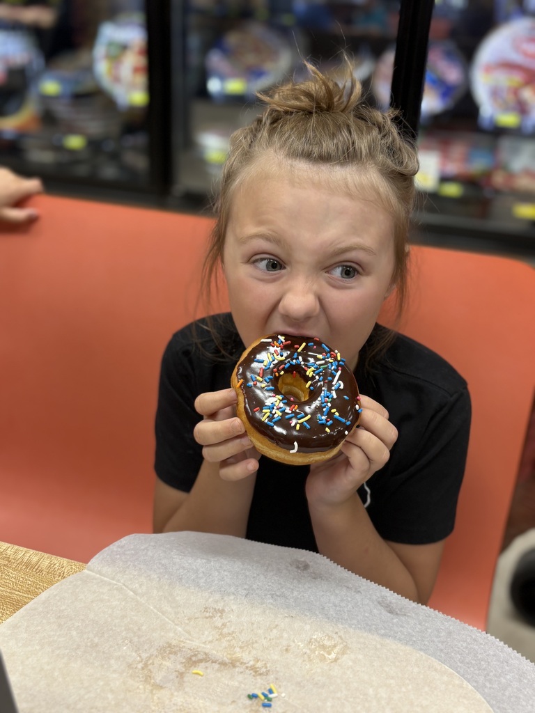 elementary student eating donut at grocery store