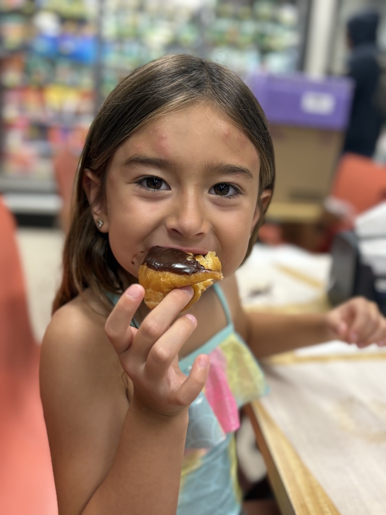 elementary student eating donut at grocery store