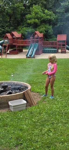 elementary student by fire pit and playground