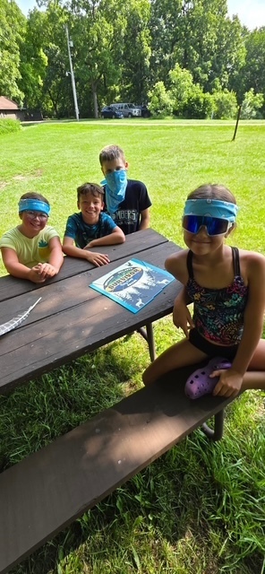 four elementary students on picnic table