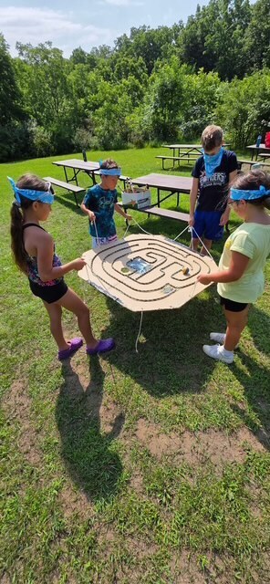 four elementary students figuring out a maze game