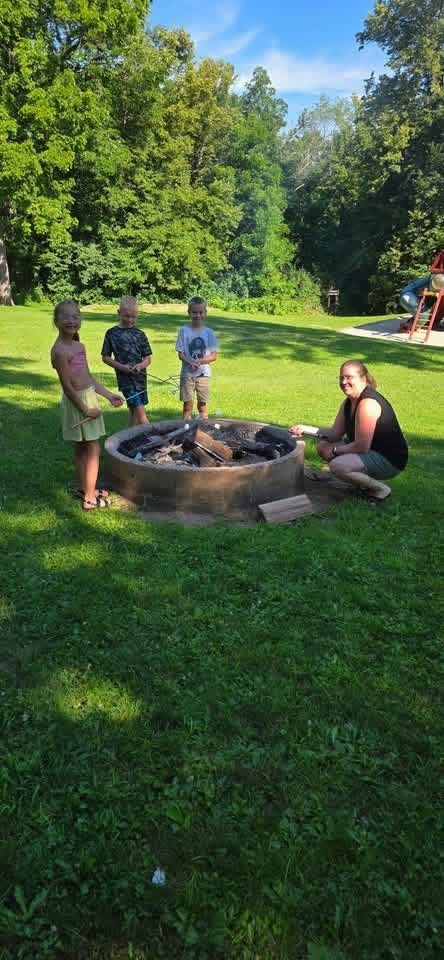 elementary students and teacher around a fire pit