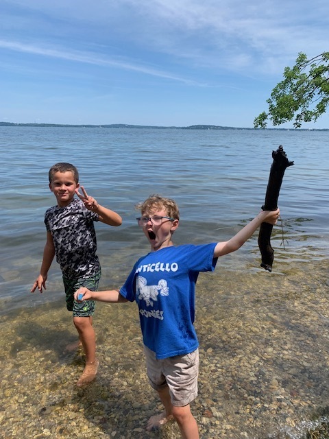 two elementary students wading in a lake