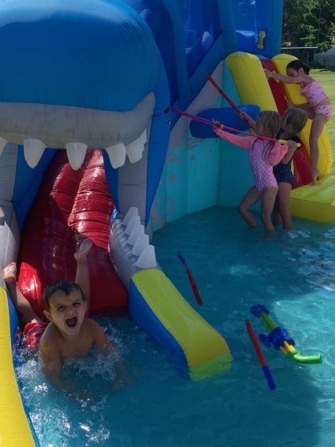 elementary students playing in blow up pool