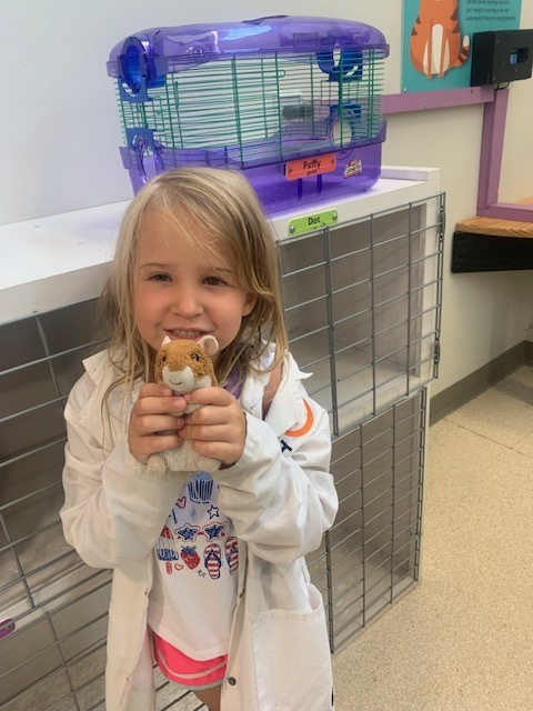 smiling elementary student holding toy hamster at Black Earth Children's Museum