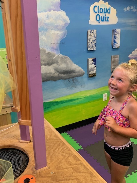 smiling elementary student playing at Black Earth Children's Museum