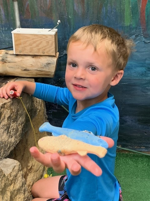 elementary student playing with toy fish at Black Earth Children's Museum