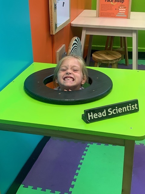 smiling elementary student playing at Black Earth Children's Museum