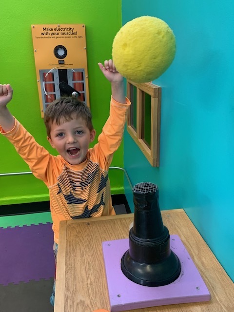 happy elementary student playing with air and ball at Black Earth Children's Museum
