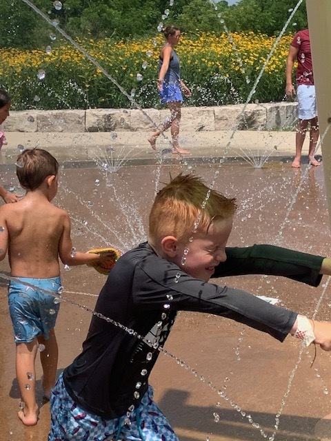 elementary students running through water at splash pad