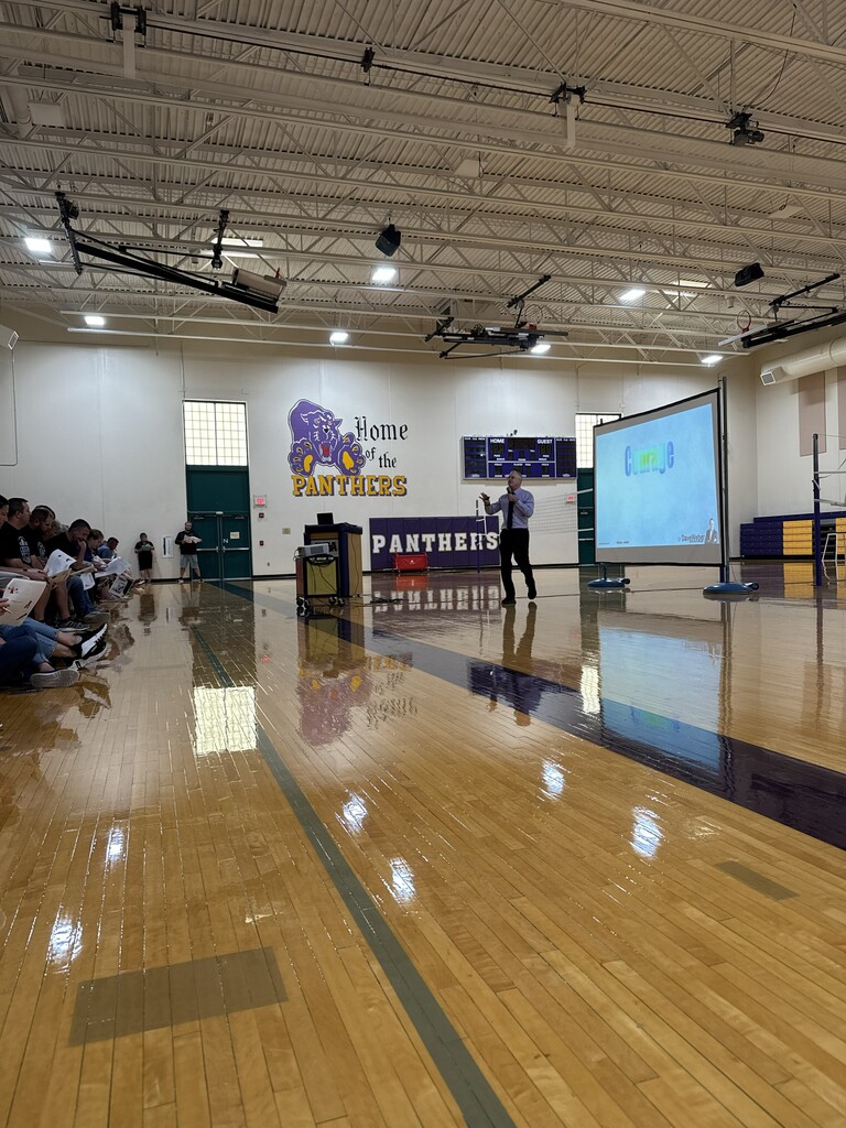 teachers and staff in gym listening to speaker