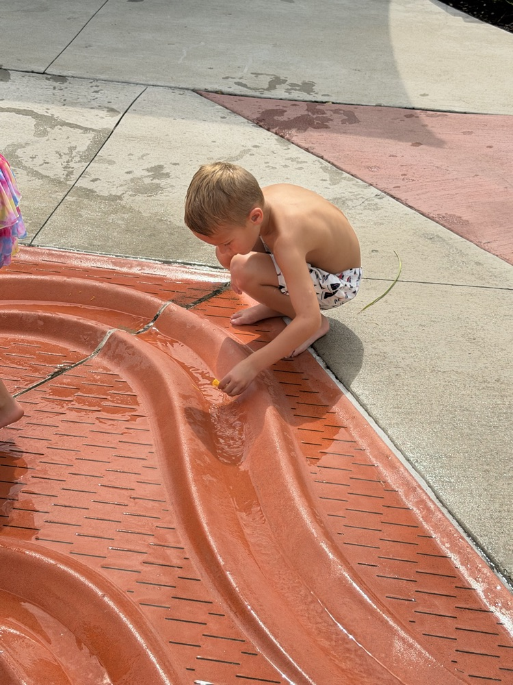 student playing at splash pad