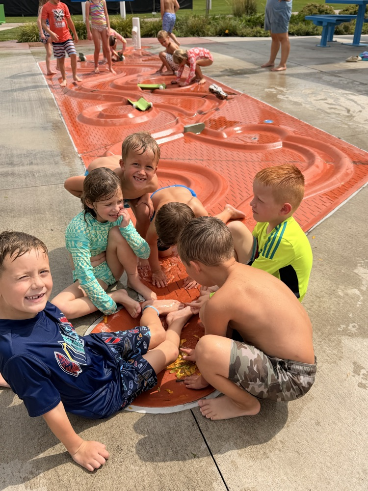 students working together at a splash pad