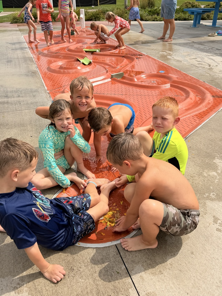 students working together at a splash pad