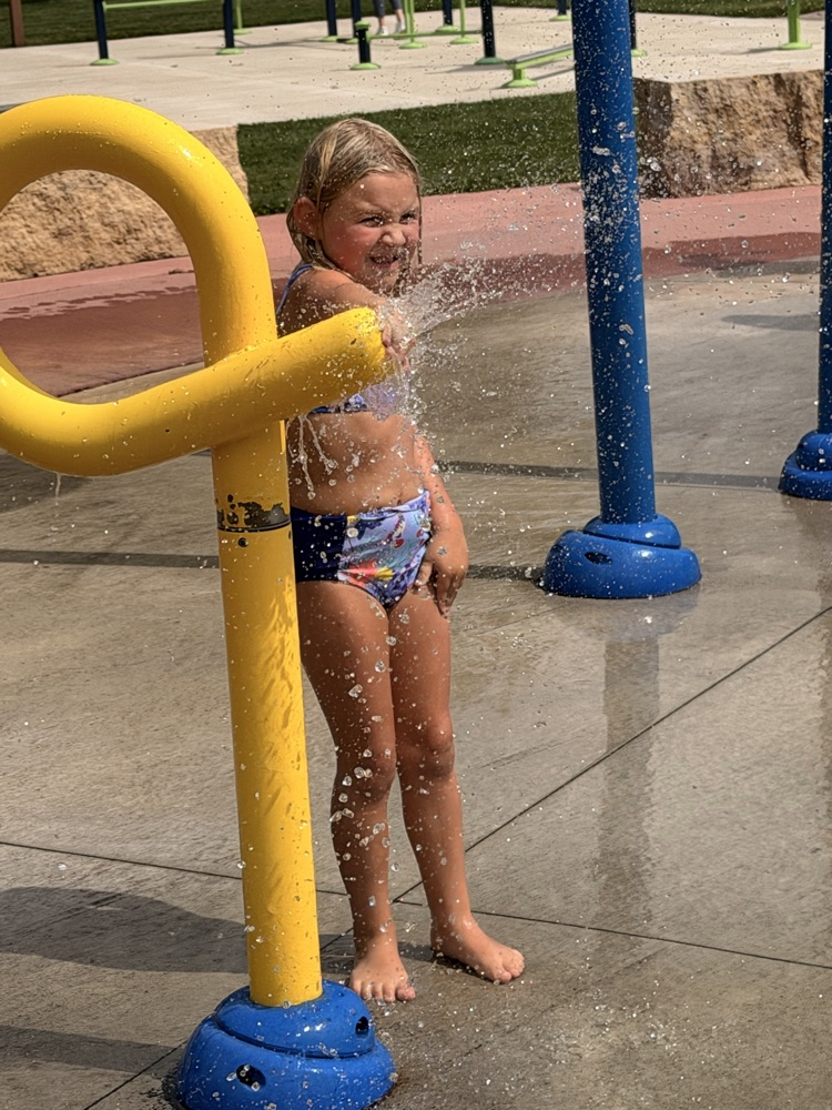 student playing with sprinkler
