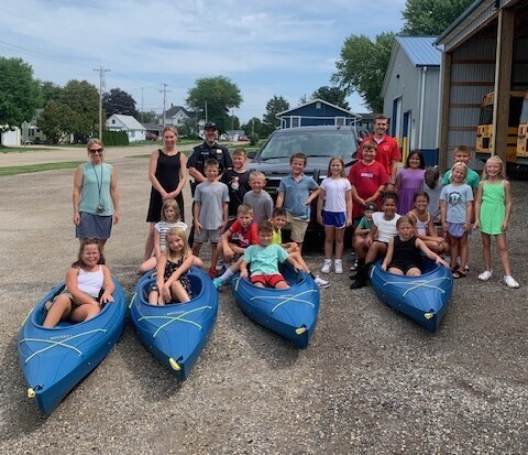 teachers, chief of police and students with kayaks