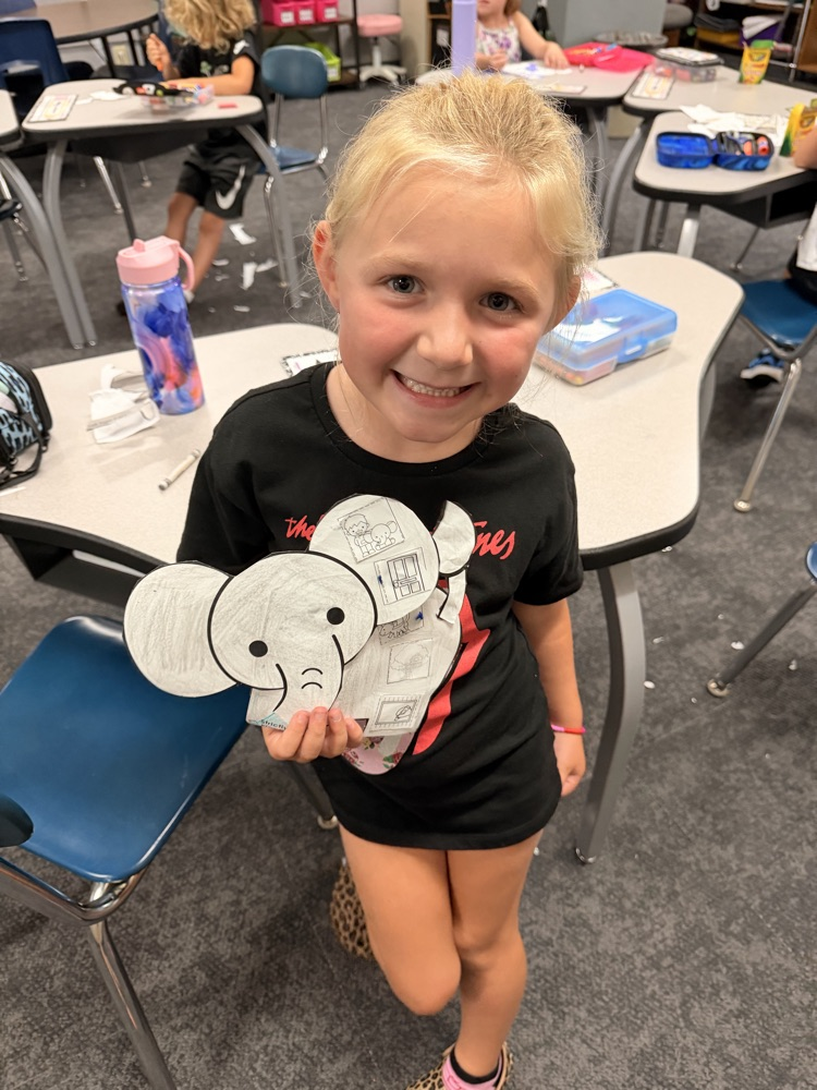 smiling first grader with paper elephant