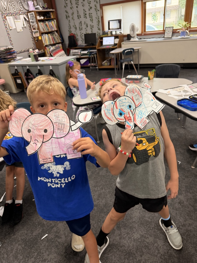 two first graders with their paper elephants