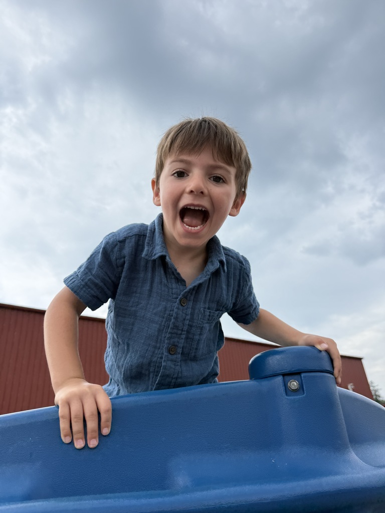 student smiling on playground equipment