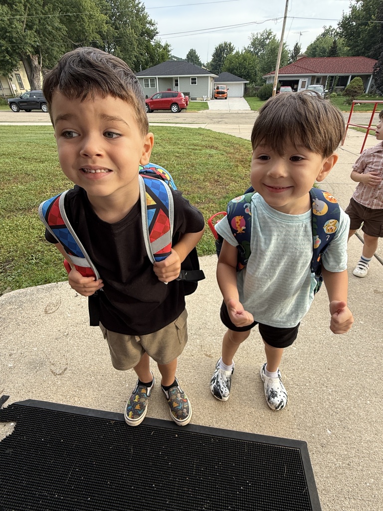 two students smiling with backpacks on