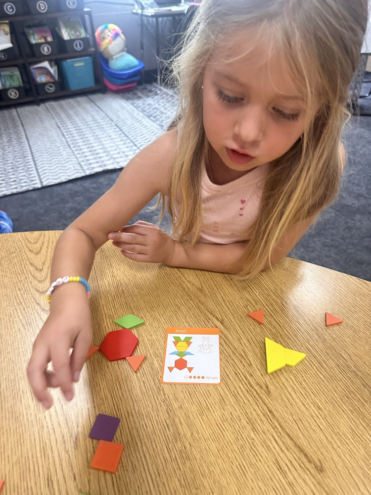 kindergartner playing a math game at the table