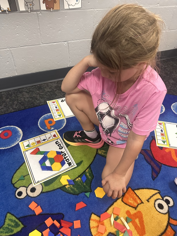 kindergartner playing a math game on the floor