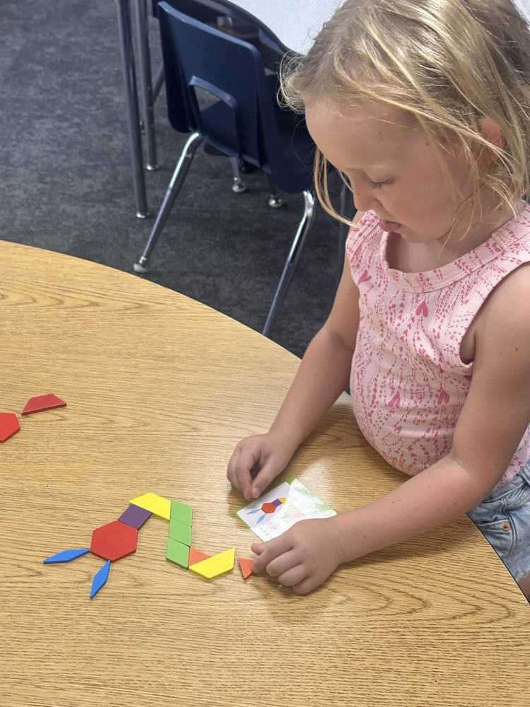 kindergartner playing a math game at the table