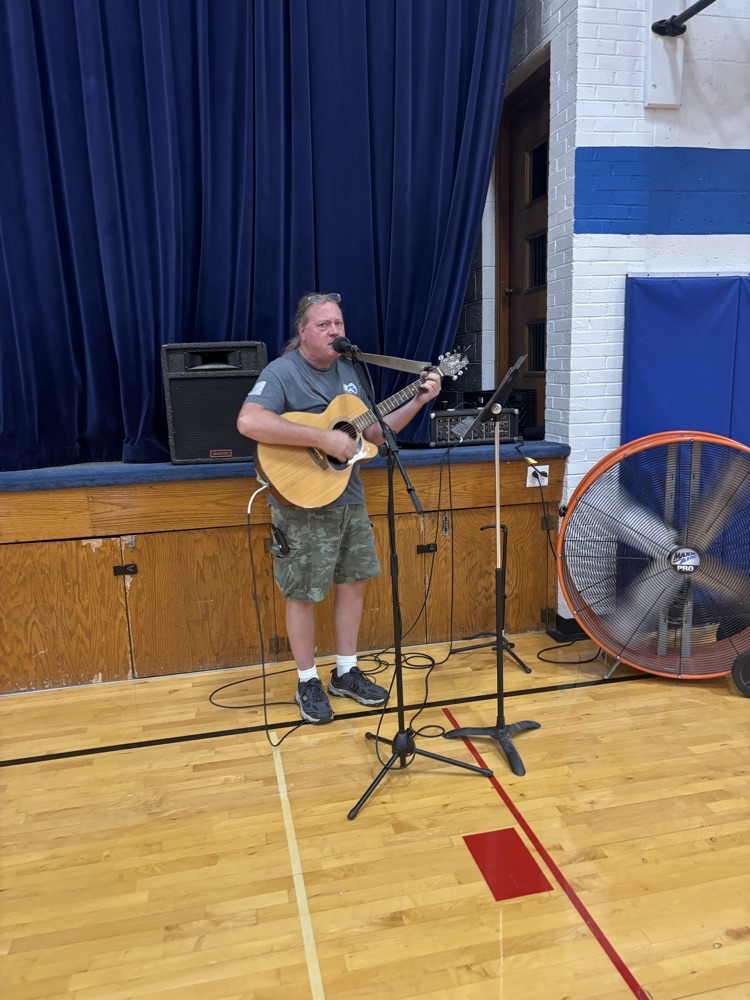 paraprofessional playing the guitar and singing