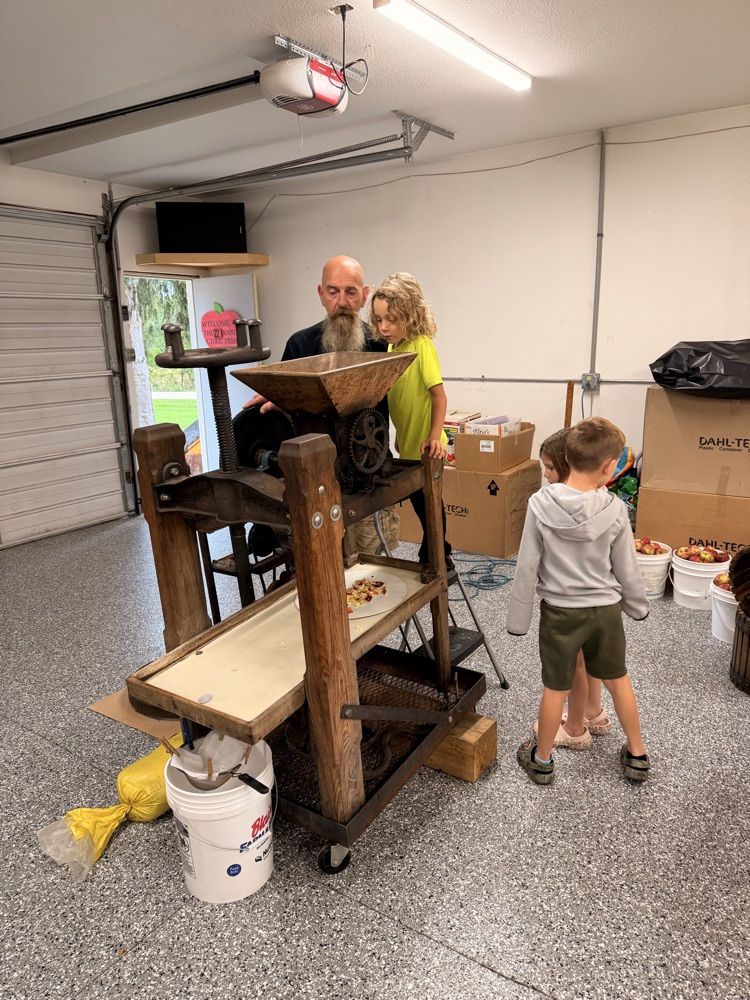 adult and students with apple press