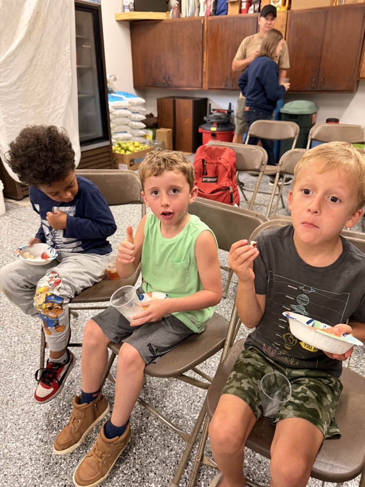 three students with apples and apple cider