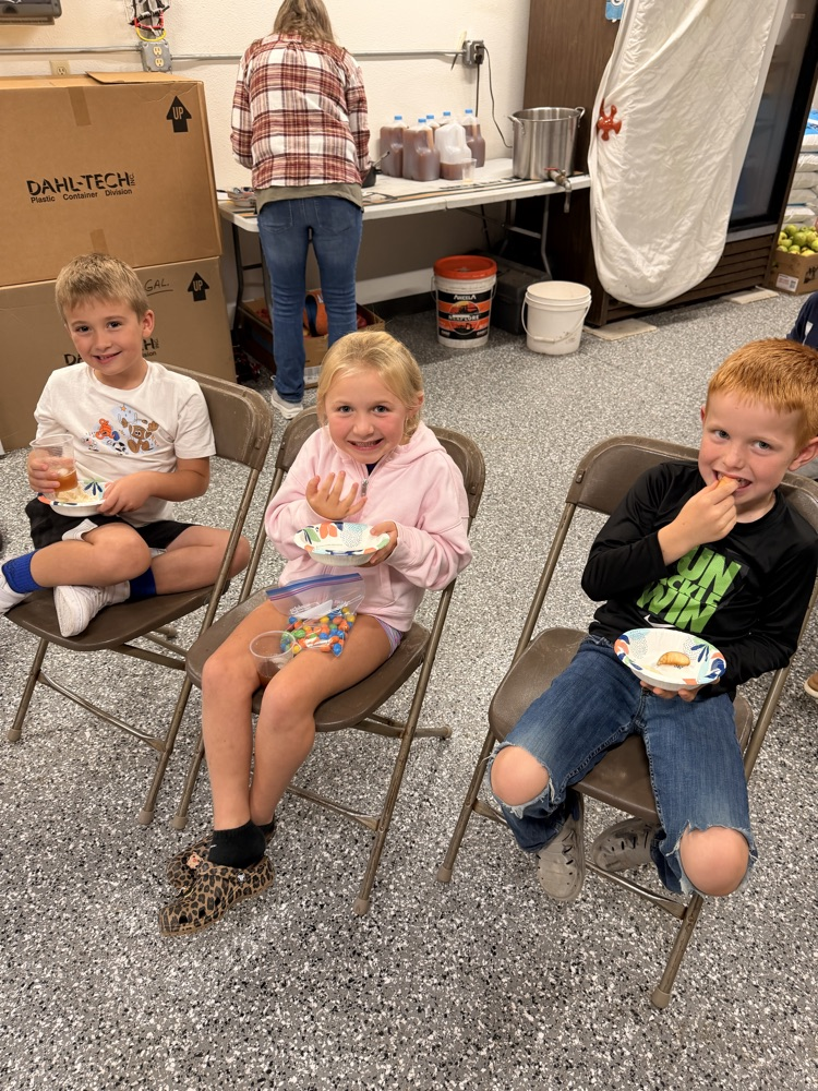 three happy students with apples and apple cider