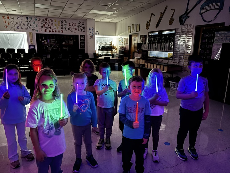 first graders holding light up batons